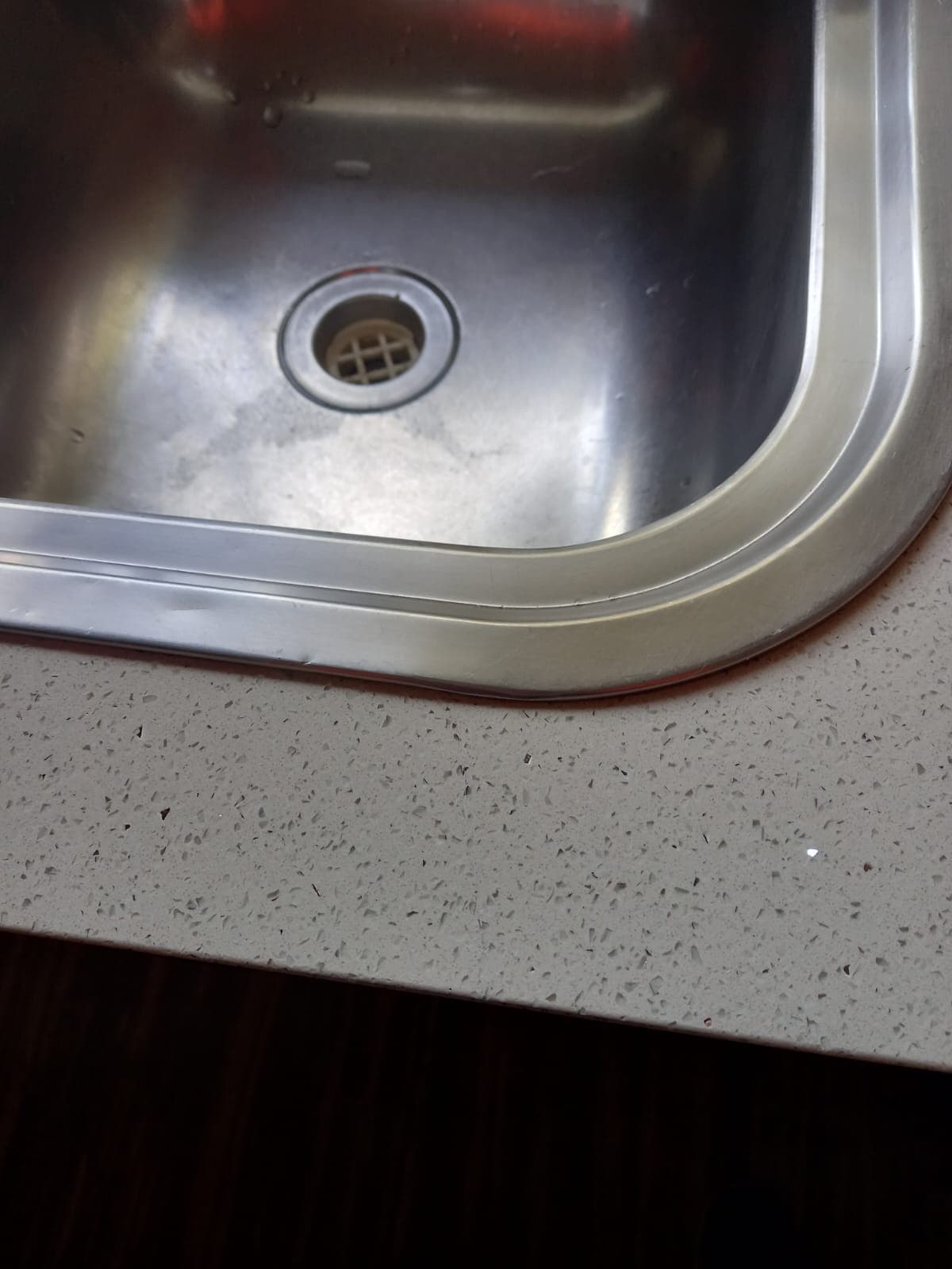 After: the engineered stone benchtop with the crack repaired and polished flush.