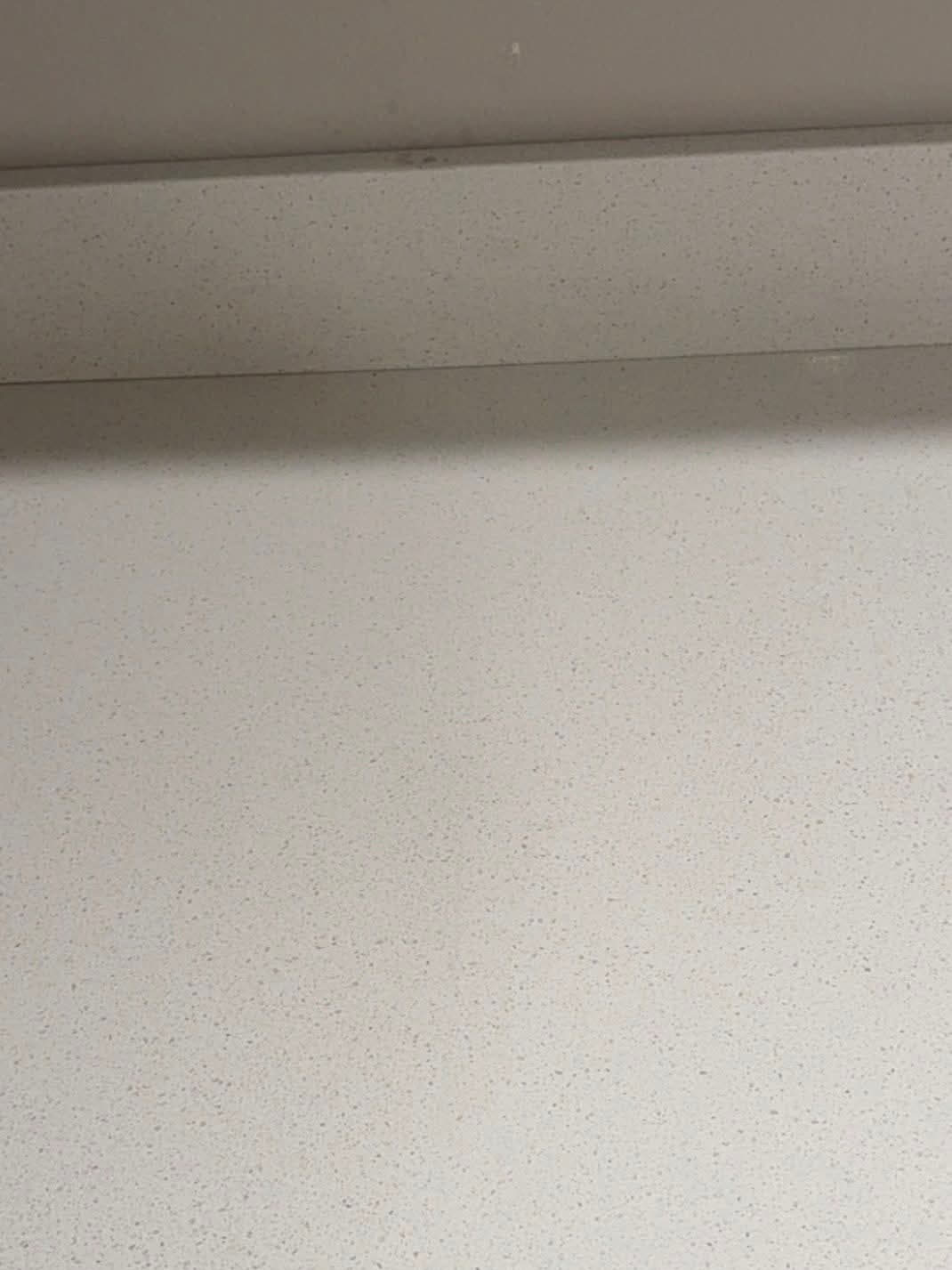 After: the white stone benchtop with the crack filled and polished to an even surface.