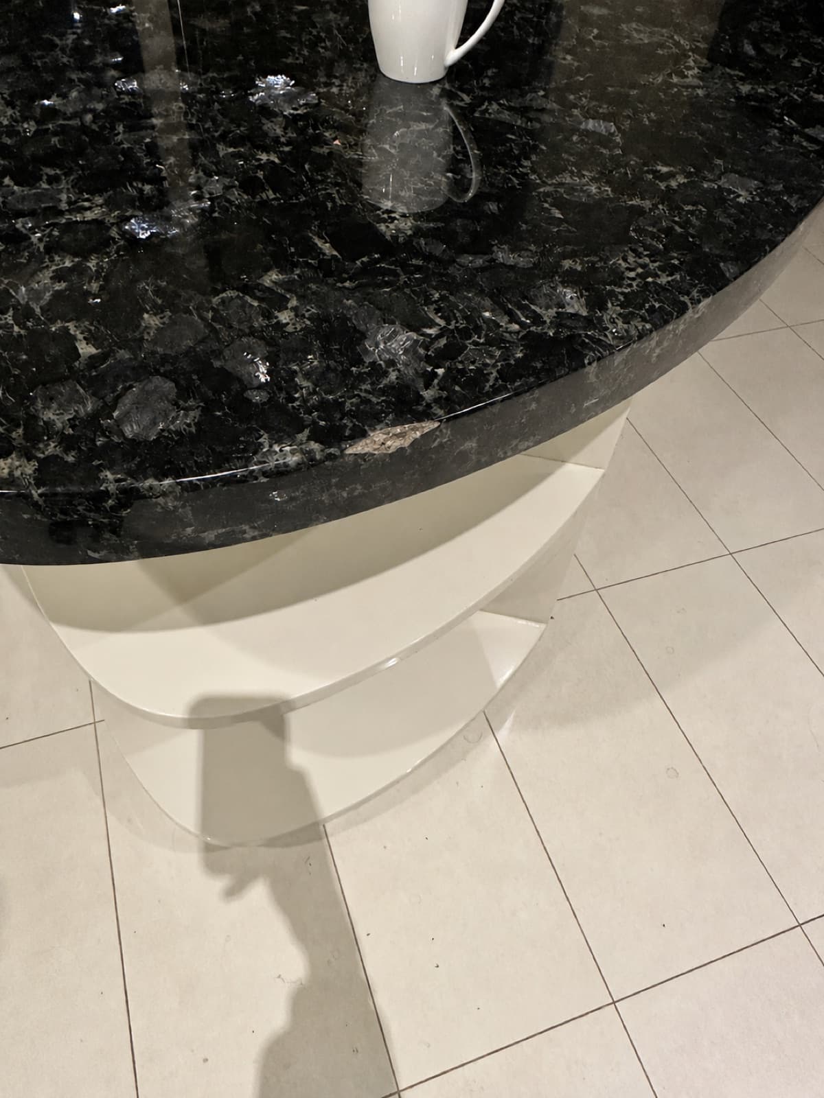 Before: a chip on the rounded edge of a dark stone kitchen benchtop.