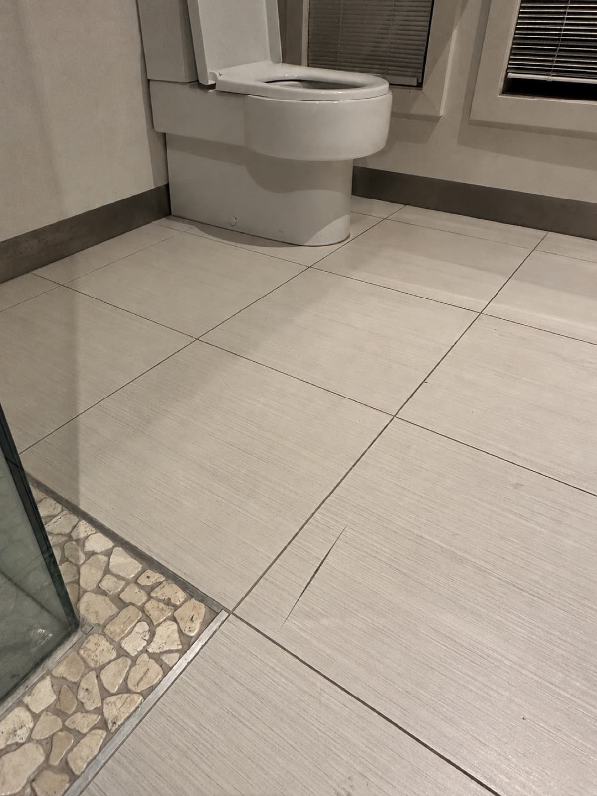 Before: a chipped ceramic floor tile in a bathroom.