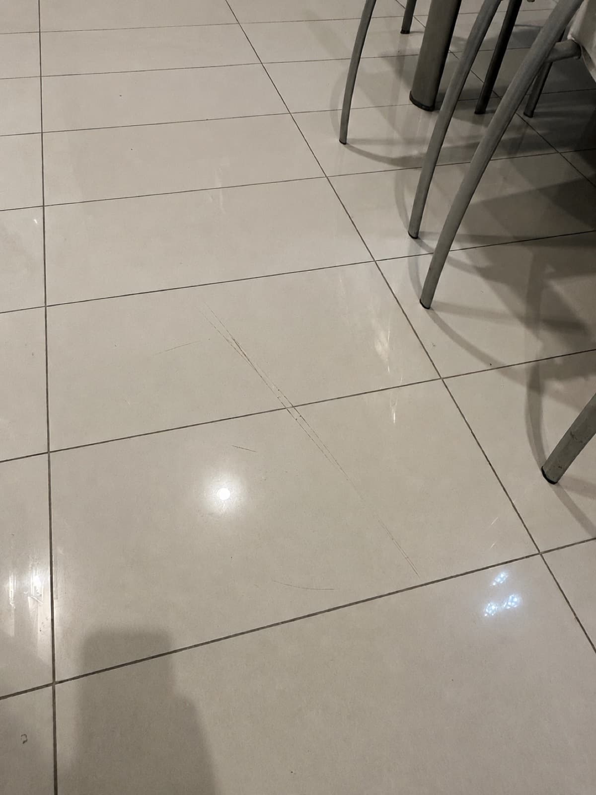 Before: a chipped ceramic floor tile in a kitchen.